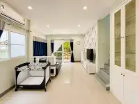 3 Bedroom House for Sale in East Pattaya open-plan living room with TV unit, staircase and glass display cabinet