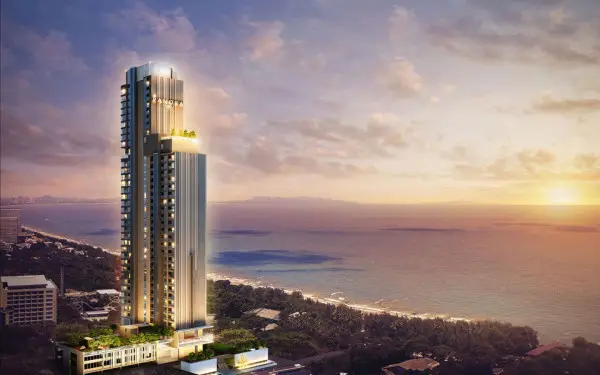 The Panora Pattaya high-rise condo building at sunset, overlooking the ocean and coastline.