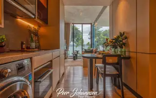 Arom Wongamat: Compact kitchenette with a washing machine, dining table, and living area with sea view.