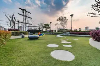 Supalai Mare Pattaya entrance with a circular building featuring 7-Eleven and a tall modern condo tower.