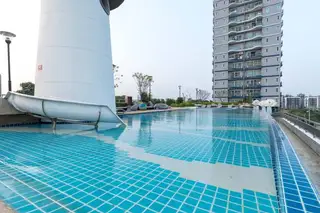 Supalai Mare Pattaya green lawn with stepping stones, a playground, and a ship-themed structure at sunset.