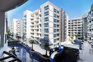 Grand Avenue Residence long, winding swimming pool with palm trees, lounge chairs, and condo building balconies.