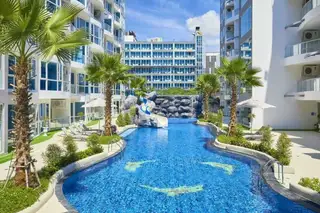 Grand Avenue Residence winding swimming pool lined with palm trees and modern condo buildings under a bright sky.