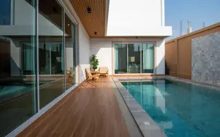 Narita Villa outdoor patio with a private swimming pool, lounge chairs, and sliding glass doors.