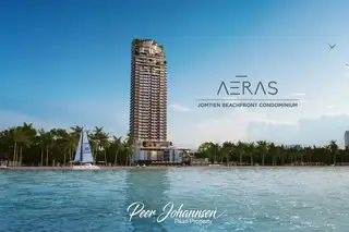 Aeras Jomtien Beachfront Condominium building with ocean, sailboat, and palm trees.