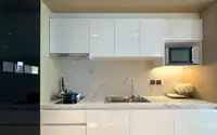 1 Bedroom Condo for Sale at Beverly Mountain Bay Pattaya modern kitchen with marble backsplash, white gloss cabinets, and built-in microwave