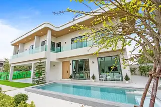 Perla Villa: Modern white house with a swimming pool, large glass doors, and balconies, under a blue sky.