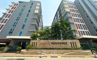 Avenue Residence modern condo buildings exterior with a stone sign displaying the property name and lush palm trees.
