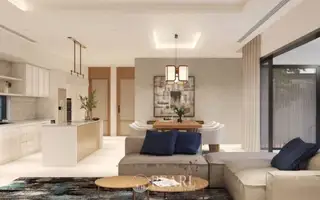Prime Habitat open-plan living room and dining area with a white sofa, wooden dining table, and kitchen island.