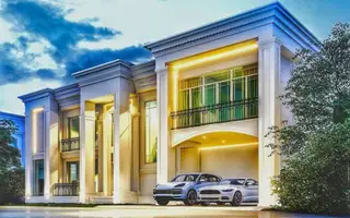 Eden Pool Villa, modern luxury house exterior with illuminated facade, balcony, and two cars parked in the integrated garage.