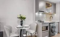 1 Bedroom Condo for Sale at Aquarous Jomtien Pattaya: Dining area for two next to a compact kitchen with appliances.