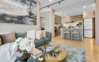 3 Bedroom Condo for Sale at Aquarous Jomtien Pattaya: Modern living room with sofa, coffee table, and open-plan kitchen with bar seating.