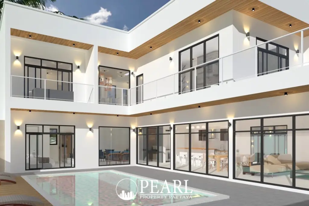 The Sugar Palm Villa, a modern white house with a central swimming pool and multiple balconies overlooking the pool area.