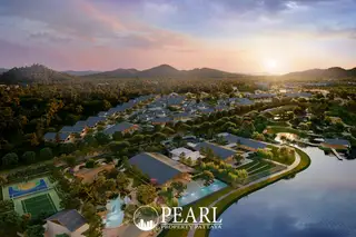 Wisdom First Residences aerial view of the resort-style condo complex with lake, sports courts, and sunset.