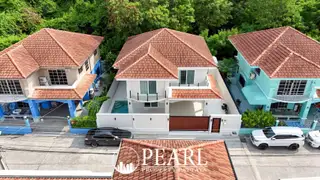 Wonderland II outdoor swimming pool with blue tiles, surrounded by houses and a covered patio in Pattaya.
