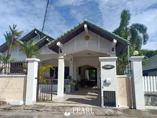 Paradise Hill 2 single-story house exterior with green roof, white pillars, and front gate.