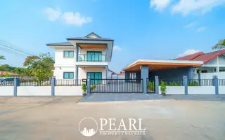 Park Rung Ruang outdoor swimming pool with two lounge chairs and a modern white house under a clear sky.