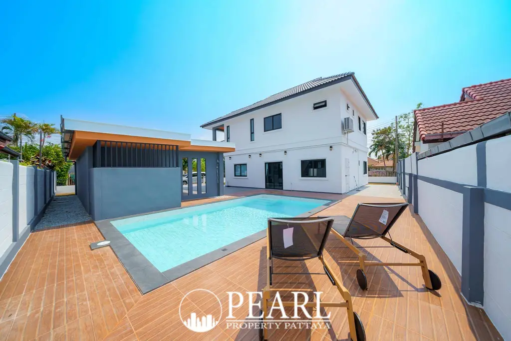 Park Rung Ruang private swimming pool with white two-story house and terracotta roof under a clear blue sky.