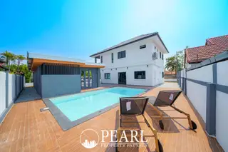 Park Rung Ruang private swimming pool with white two-story house and terracotta roof under a clear blue sky.
