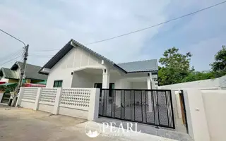 Paradise Hill 2 single-story house with white exterior, grey roof, and black decorative gate.
