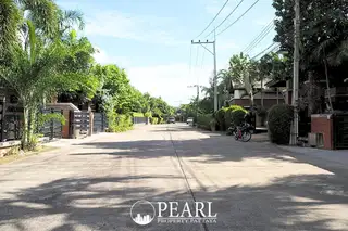 Mantara Village main entrance with a prominent oval sign, lush green hedges, and a wooden overhead structure.