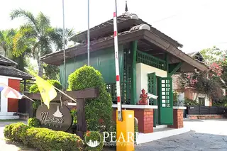 Mantara Village security gate with a red and white barrier, guardhouse, and tropical landscaping.