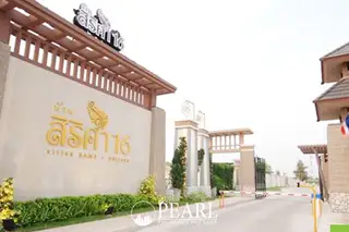 Sirisa 16 main entrance gate with a large sign displaying the property name in Thai and English, and a security barrier.