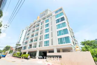 The Elegance condo building entrance with a sign displaying the property name and a car parked.