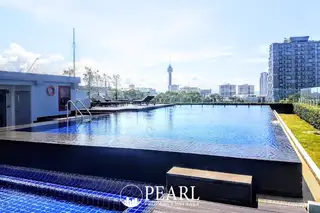 The Elegance rooftop swimming pool with city views, including the Pattaya Tower in the distance.