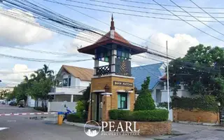 Baan Natcha Village entrance gate with traditional Thai-style guardhouse and security barrier.