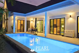 Parkside Pool Villas street view with modern grey-roofed houses and a long privacy wall.