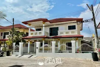 Eakmongkol 3 modern two-story house with red tiled roof, white facade, and ornate fence.