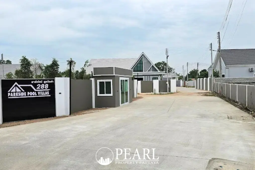 Parkside Pool Villas main entrance gate with guardhouse and paved road leading into the community.