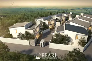 Thamber Private Pool Villa aerial view of modern villas nestled in a green forest, with a gated entrance and road.
