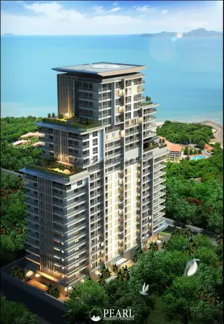 Cosy Beach View modern condominium building exterior with balconies, lush green trees, and ocean in the background