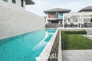 Patta Ville outdoor communal area with modern paving, seating, trees, and contemporary houses.