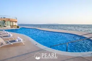 La Royale Beach grand entrance with dual staircases leading to a pool area and illuminated lobby at dusk.