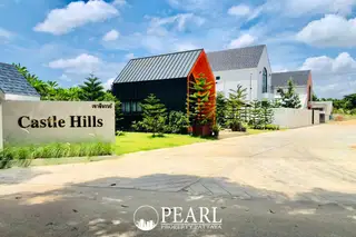 Castle Hill entrance sign with modern houses and green landscaping under a blue sky.