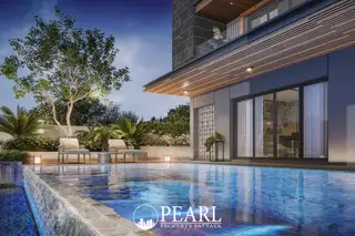 The Arowanyx swimming pool with blue tiled bottom, lounge chairs, and lush landscaping at dusk.