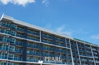 Sea Saran modern condominium building exterior with multiple balconies and a clear blue sky.