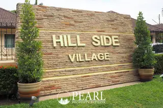 Hillside Village Pattaya modern house exterior with lush green lawn, covered carport, and large windows.