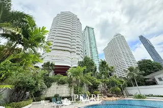 Sliver Beach exterior view of multiple tall condo buildings, including a white high-rise, surrounded by dense tropical foliage and a pool.