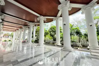 Sliver Beach elegant covered walkway with white classical columns, a polished marble floor, and green garden views.