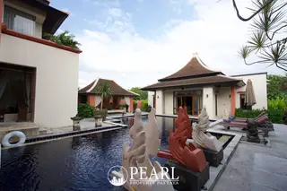 Phutara outdoor swimming pool with decorative statues, surrounded by traditional Thai-style buildings.
