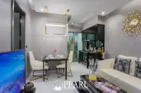 1 Bedroom Condo for Sale at Grand Solaire Pattaya: Living area with dining table, sofa, TV, and modern kitchen.