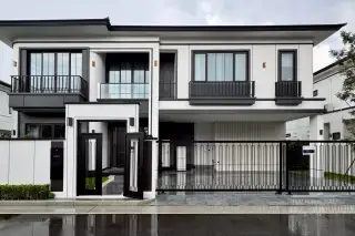 Chieftain modern two-story house with white facade, black trim, large windows, and a covered parking area.