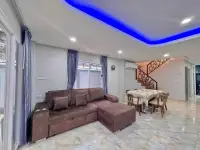 4 Bedroom House for Rent in East Pattaya living room with brown sofa and blue accent ceiling lighting