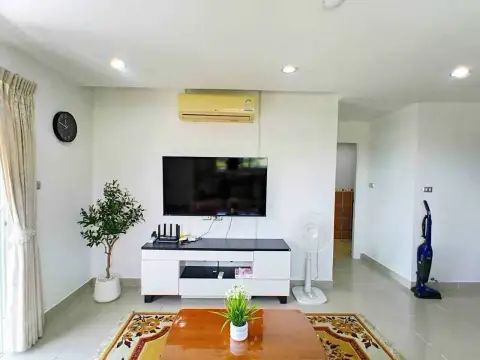 1 Bedroom Condo for Rent at Porch Land 2 living room with wall-mounted TV and air conditioning unit