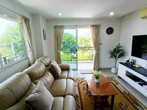 1 Bedroom Condo for Rent at Porch Land 2 living room with balcony access and green outdoor view