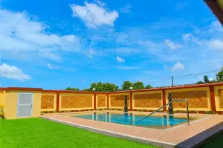 Miami Villas swimming pool with decorative statues herringbone brick boundary wall and manicured green lawn